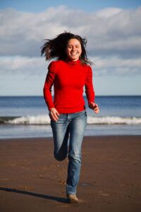 Woman running on beach energy boost