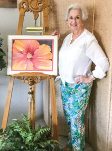 Beverly Dean showing off one of her paintings